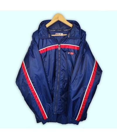 Manteau Fila bleu marine, deux poches à zip. Logo en patch brodé au niveau du coeur. Capuche se roule dans le col